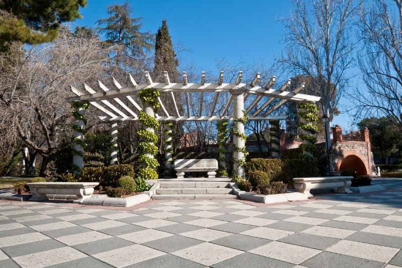 white painted wood pergola sorrounded by plants