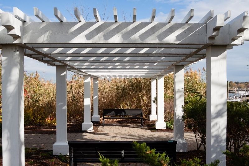 wthite colored timber pergola with black chairs