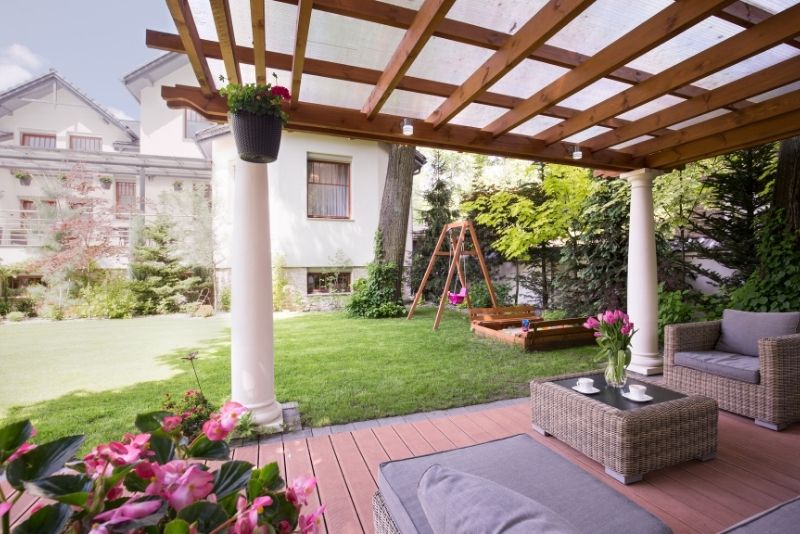 patio with covered pergola having pink flowers