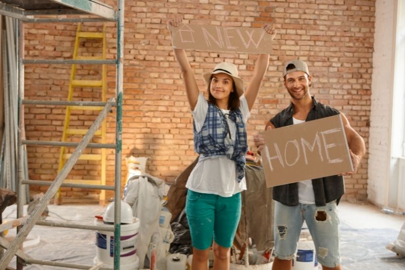 girl and a boy holding a Placard saying new home